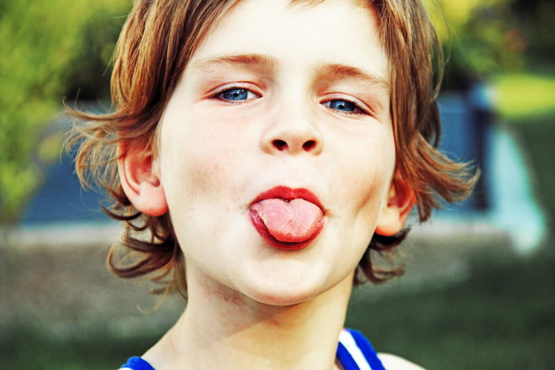 Kind streckt die Zunge raus